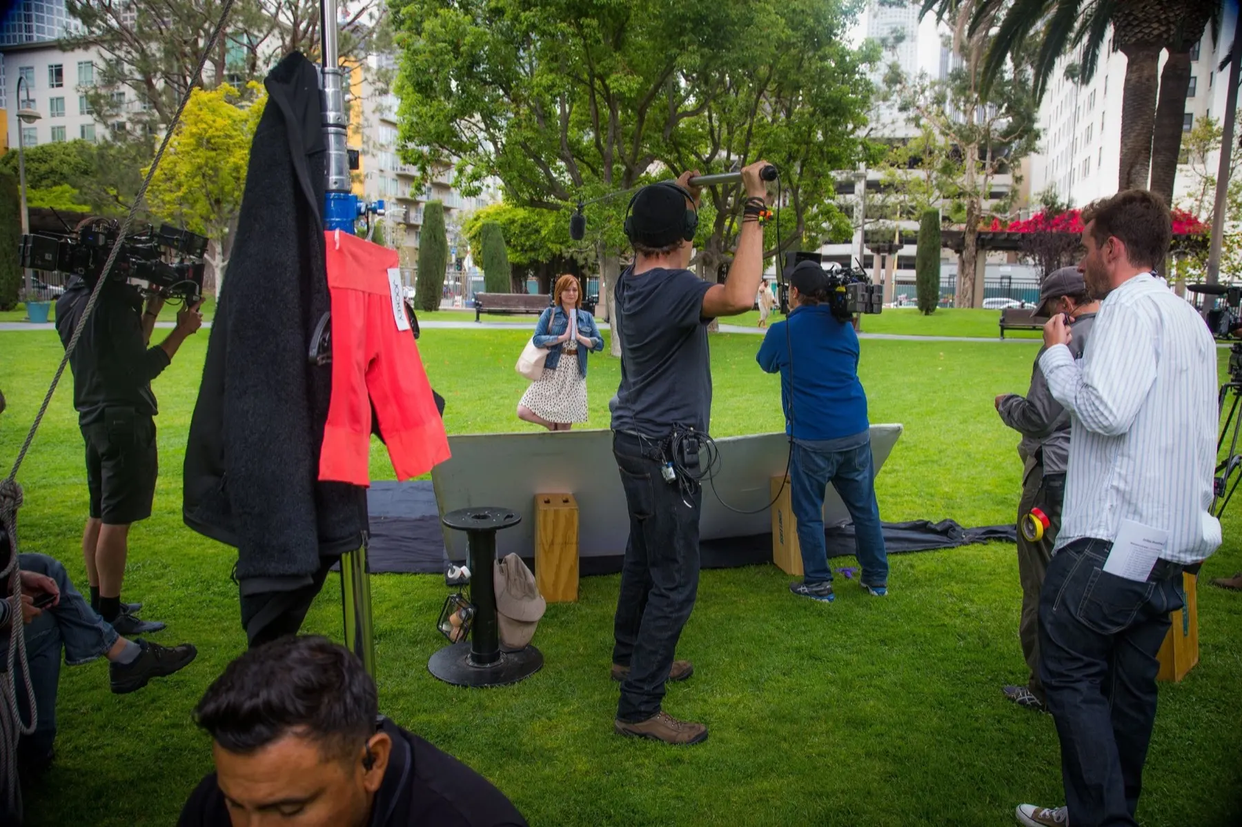 Full production crew on location with crane rig visible in downtown Los Angeles park