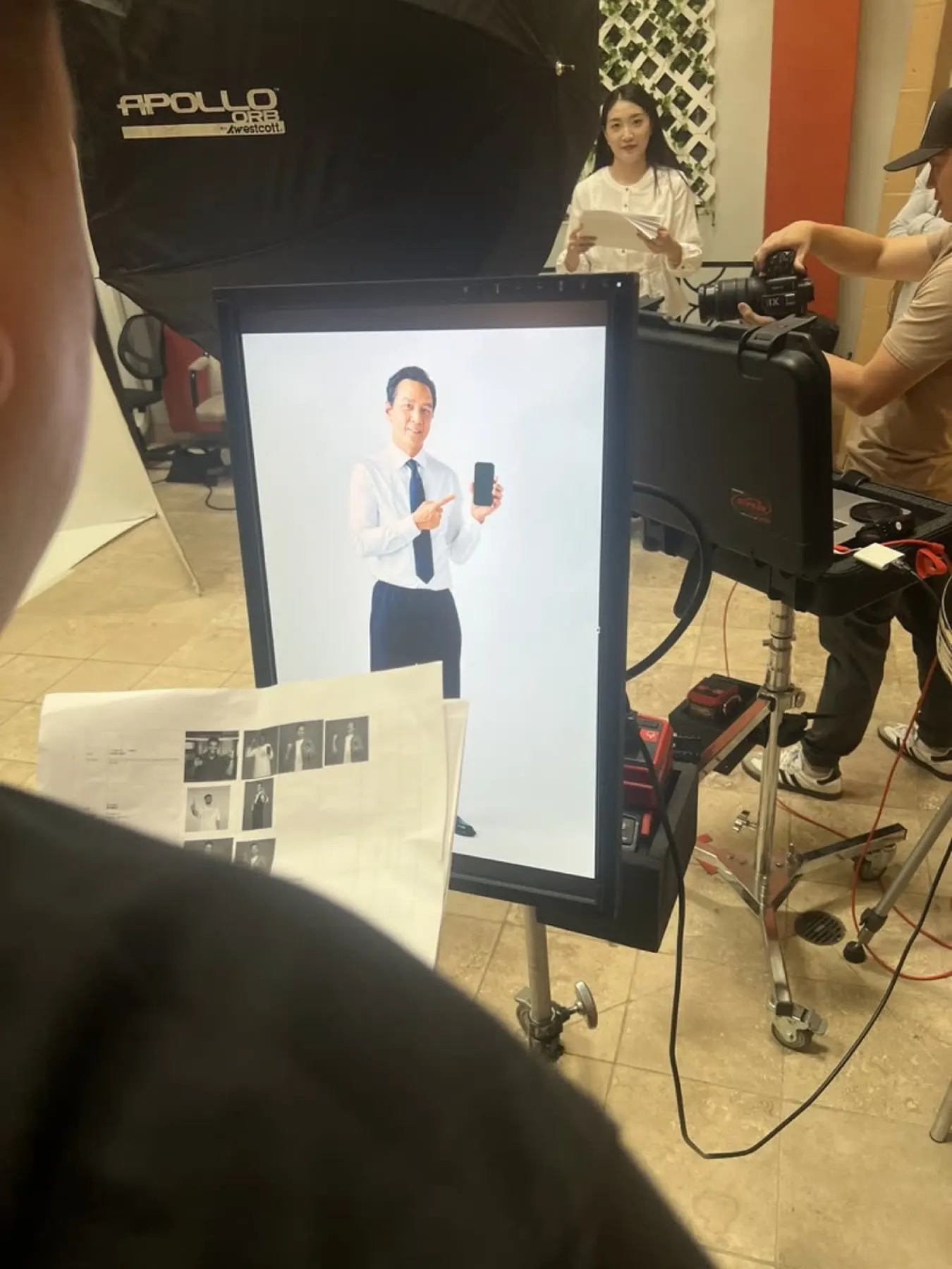 Daniel Wu holding Last War phone on studio set